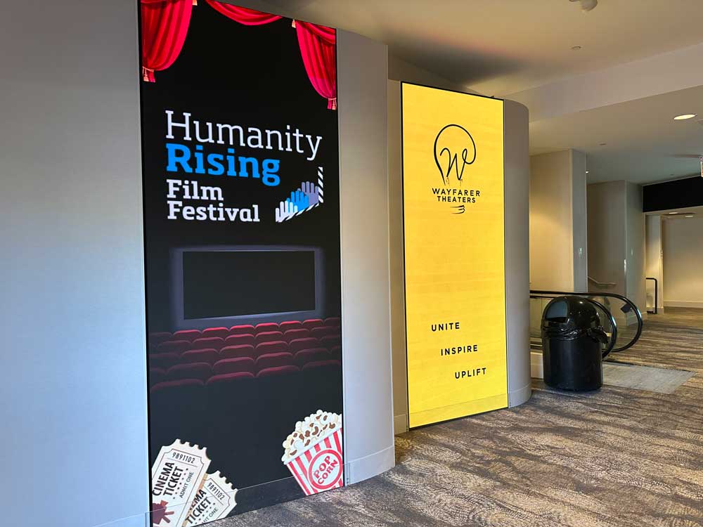 Humanity Rising Film Festival sign next to Wayfarer Theater sign in the lobby of the theater